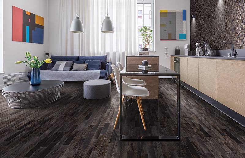Pour des économies à long terme, optez pour un revêtement de sol résistant et de qualité Salle à manger et cuisine au plancher foncé et résistant