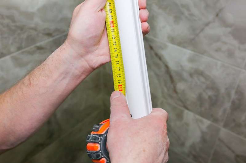 Prendre les mesures nécessaires avec un ruban à mesurer Prise de mesure d’une moulure blanche